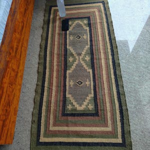 以下が含まれることがあります： 黒いハンドルと黒い太字の「But First, Coffee」のテキストが入った白いセラミックマグ。マグは白い表面に置かれています。マグの高さは約10cmです。