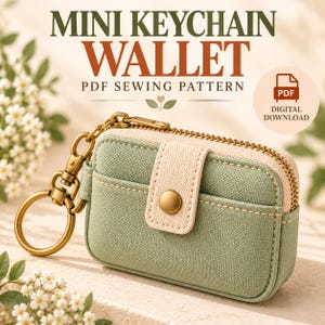 May include: A sage green mini keychain wallet with a cream-colored snap-button strap, a gold-tone zipper, and a matching gold-tone keyring. The text reads MINI KEYCHAIN WALLET PDF SEWING PATTERN and PDF DIGITAL DOWNLOAD.