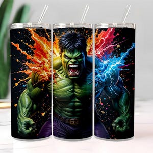 Puede incluir: Tres vasos de acero inoxidable con pajitas, cada uno con una vibrante ilustración de Hulk. El diseño muestra la cara y la parte superior del cuerpo de Hulk, con efectos de relámpagos naranjas y azules. Los vasos tienen un fondo negro.