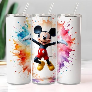 May include: White tumbler featuring Mickey Mouse with a colorful watercolor splash design. The tumbler has a silver lid and a clear straw. Mickey Mouse is wearing red shorts, yellow shoes, and white gloves.