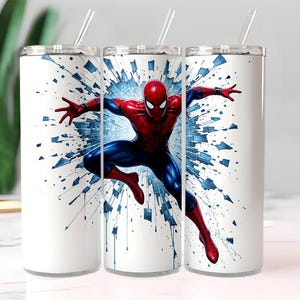 May include: Three white stainless steel tumblers with a Spider-Man graphic. The superhero is depicted in a dynamic pose, wearing his signature red and blue suit, against a blue and white burst background. Each tumbler has a silver lid and a clear straw.