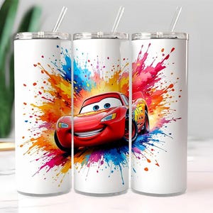May include: Three white insulated tumblers with a red Lightning McQueen graphic and colorful paint splatter design. Each tumbler has a silver lid and a clear straw. The design features the character from the Cars movie.
