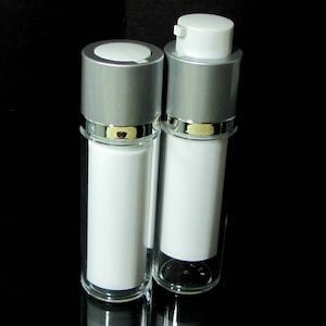 May include: Two clear plastic bottles with silver and gold caps. The bottles are empty and have a white label.