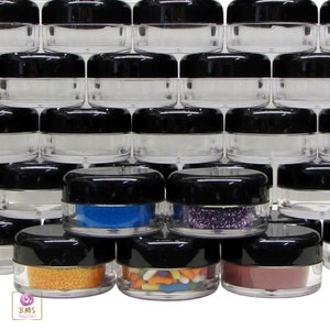 May include: A collection of clear plastic jars with black lids. The jars are filled with various colorful sprinkles, glitter, and other decorative items.