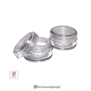 May include: Three clear plastic containers with silver lids. The containers are small and round, and they are perfect for storing small amounts of cosmetics or other products.