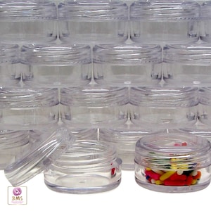 May include: A stack of clear plastic containers with lids. The containers are round and have a smooth finish. One container is open and filled with colorful sprinkles.