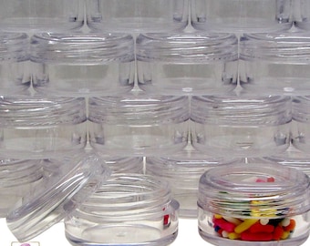 May include: A stack of clear plastic containers with lids. The containers are round and have a smooth finish. One container is open and filled with colorful sprinkles.