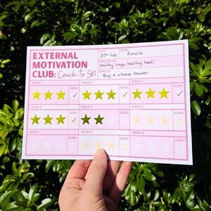 Könnte beinhalten: Ein rosa Papier-Gewohnheitstracker mit dem Titel External Motivation Club: Couch to 5K. Er enthält Felder für Name, Datum, Motivation und Belohnung. Das Raster umfasst neun Wochen mit goldenen Sternaufklebern und Done-Kontrollkästchen.