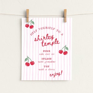 May include: A white poster with pink vertical stripes and red text, clipped to a clothesline with wooden clothespins. The poster reads "Help Yourself to a Shirley Temple" with instructions and cherry illustrations.