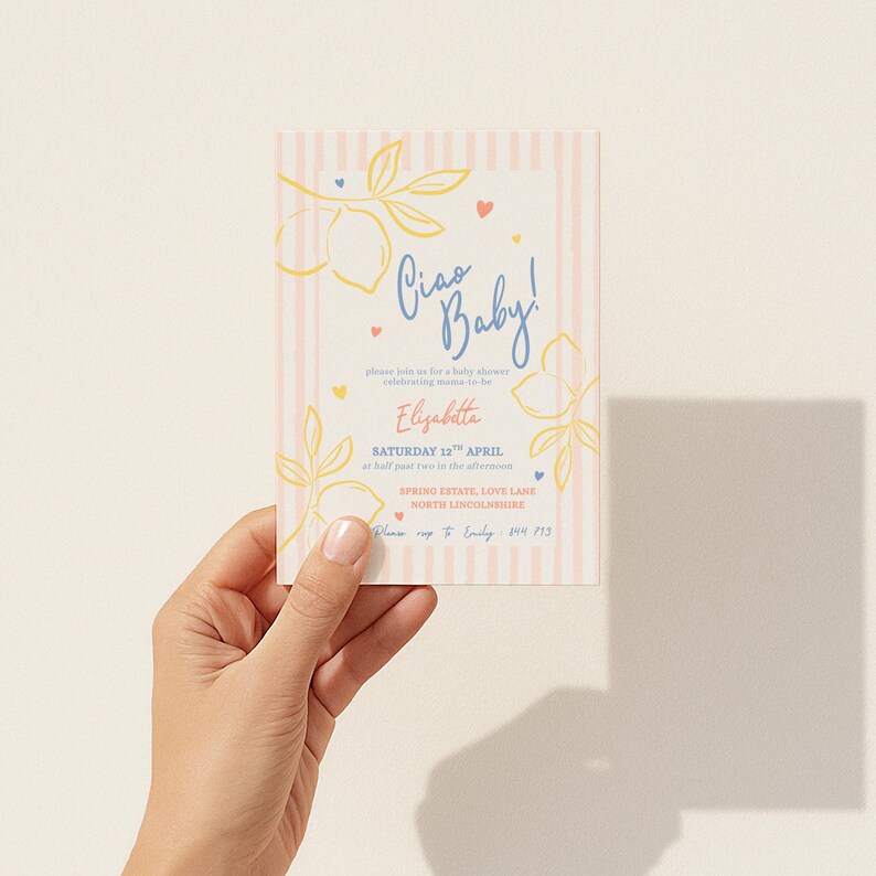 Puede incluir: Una invitaci&oacute;n para baby shower con un fondo de rayas verticales rosas y blancas. La invitaci&oacute;n presenta el texto "Ciao Baby!" en escritura azul, junto con ilustraciones florales y de limones. La invitaci&oacute;n se sostiene en una mano.