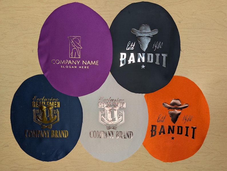 Puede incluir: Cinco parches de tela circulares en varios colores: morado, negro, naranja, azul marino y gris claro. Cada parche presenta un logotipo y texto diferentes, incluyendo "COMPANY NAME", "BANDIT" y "Exclusive Gentlemen."