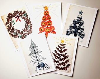 Puede incluir: Conjunto de cinco tarjetas de felicitación con temática de Halloween. Los diseños incluyen una corona de murciélagos, un árbol de calabazas, un árbol de calaveras, un árbol de telaraña con una araña y un árbol de murciélagos.