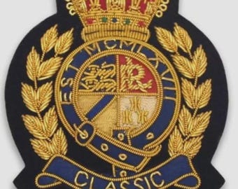 May include: A navy blue embroidered patch with a gold crown, laurel leaves, and a central emblem. The emblem features a shield design with gold, red, and blue elements, and the word "CLASSIC" is displayed on a blue banner.