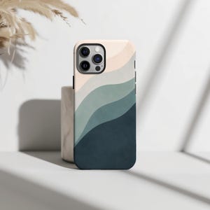 May include: A smartphone case featuring a layered, wavy pattern in shades of cream, light grey, sage green, and dark navy blue. The design covers the back of the case, which has a rectangular cutout for the camera lenses in the upper left corner.
