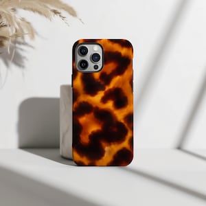 May include: A rectangular smartphone case featuring a glossy, amber and dark brown tortoiseshell pattern. The case has a precise cutout for a triple-lens camera system on the upper left corner, showcasing a smooth, polished finish throughout.