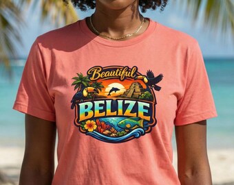 May include: Coral-colored t-shirt featuring a colorful graphic design with the text "Beautiful Belize." The design includes toucans, palm trees, a sunset, and a depiction of the Belize Barrier Reef. The shirt is short-sleeved.