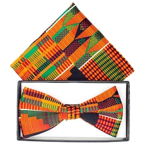 May include: A bow tie and pocket square set with a colorful geometric pattern in shades of orange, yellow, green, and black. The pattern is reminiscent of traditional African textiles.
