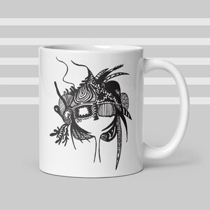 May include: White ceramic mug with a black and white abstract design. The artwork features intricate patterns, lines, and shapes, creating a unique aesthetic. The mug has a standard handle and a glossy finish.