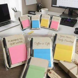 May include: A collection of packaged sticky note pads with pens. The pads come in pink, blue, yellow, and green, with phrases like "Planning to Quit Later" and "Coffee is Life." The pens are black, and the packaging is clear.