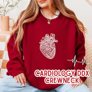 May include: A maroon crewneck sweatshirt with a white anatomical heart design filled with medical terms. The text "CARDIOLOGY DDX CREWNECK" is printed in white at the bottom. A white EKG line is on the right side.