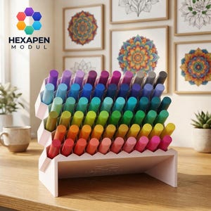 Può includere: Un organizer da scrivania modulare bianco con una struttura a griglia esagonale che contiene una collezione di pennarelli in un gradiente di colori tra cui viola, blu, verde, giallo, arancione e rosa. L'organizer presenta un design a gradini.