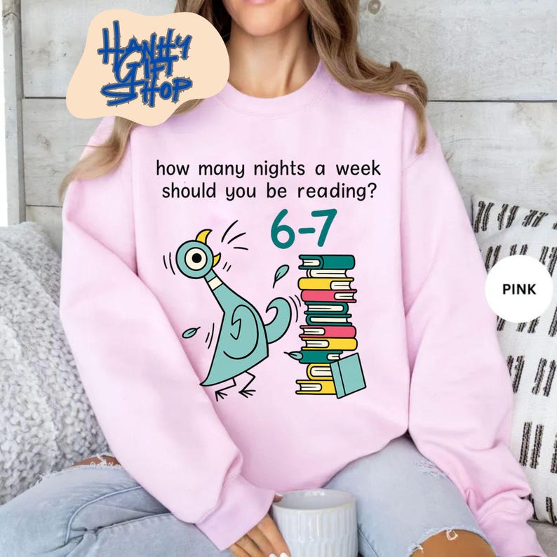 May include: Pink sweatshirt with the text "how many nights a week should you be reading?" and the numbers "6-7". A cartoon pigeon and a stack of books are also featured on the front. The word "PINK" is in a white circle.