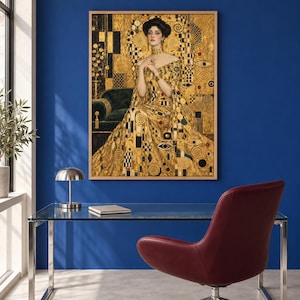 May include: A framed wall art print featuring Gustav Klimt's Portrait of Adele Bloch-Bauer I. The painting depicts a person in a gold dress with geometric patterns, seated against a gold background with swirling motifs and dark accents.