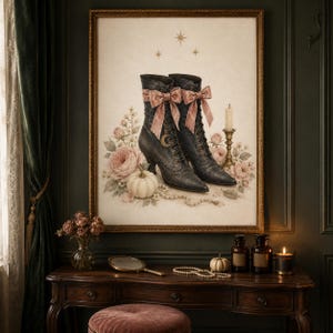 Pode incluir: Uma impressão artística emoldurada apresentando um par de botas pretas com atacadores, adornadas com laços de veludo rosa e um pendente de lua crescente dourada. As botas estão rodeadas por rosas cor-de-rosa, uma abóbora branca e pérolas.