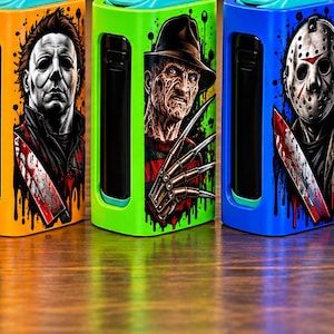 May include: A collection of seven rectangular electronic vaporizers, each featuring a distinct horror movie character graphic. The devices are colored black, red, orange, green, blue, purple, and pink, with each displaying a unique villain illustration.