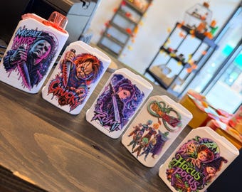Puede incluir: Cinco fundas rectangulares blancas de plástico para vapeadores con coloridos estampados gráficos de Michael Myers, Chucky, Rumi, Dragon Ball Z y Hocus Pocus. Cada funda muestra ilustraciones detalladas de personajes con logotipos.