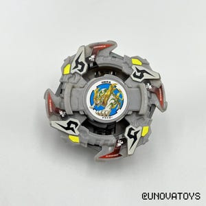 May include: A grey and yellow toy with a circular design. The centre features a circular image of a tiger. The toy has several angular pieces with the word "ORIGER" printed on them. The toy is on a white surface.