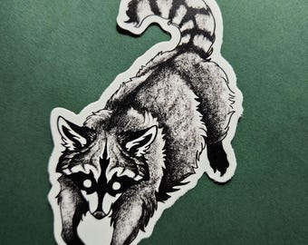May include: Black and white raccoon sticker with a detailed illustration. The raccoon is depicted in a running pose, with its striped tail curved upwards. The sticker has a white border and is set against a green background.