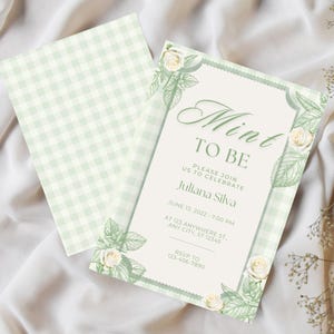 Può includere: Invito a tema menta con motivo a quadretti vichy verde chiaro sul retro e un fronte color crema. L'invito presenta il testo "Mint to Be" e i dettagli dell'evento, accentuati da illustrazioni floreali e di foglie.