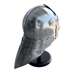 May include: A polished steel houndskull bascinet helmet featuring a pointed visor with multiple articulated plates, a rounded skull cap, and a small gold-toned floral rivet detail on the side. The letters RZ are printed in black on the visor.