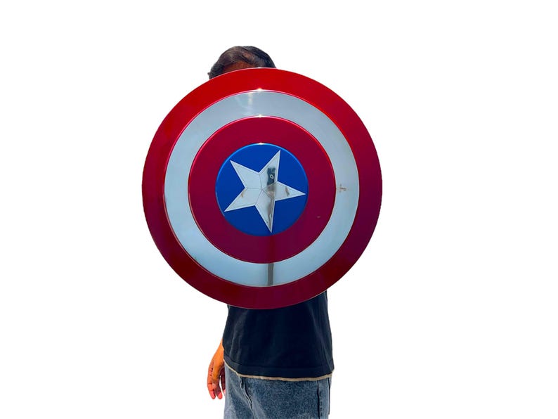 May include: A red, white, and blue Captain America shield. The shield has a red outer ring, a white inner ring, and a blue center with a white star. The shield is a circular shape.