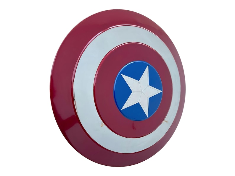 May include: A red, white, and blue shield with a star in the center. The shield is round with concentric circles of red, silver, and red. The center has a blue circle with a white star.