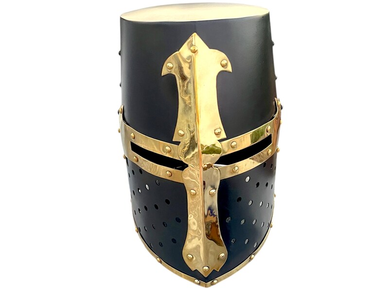 Pu&ograve; includere: Elmo medievale nero e oro con un design a croce. L'elmo ha una parte superiore arrotondata e una protezione per il viso con piccoli fori di ventilazione. Gli accenti dorati includono una croce e delle fasce.