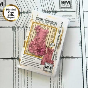 May include: A sewing pattern package for a corset mini dress with a full lace-up back. The cover features a pink dress adorned with fabric flowers and a smaller image of the lace-up back. The text reads KarenM Self-Taught Sewing Patterns.