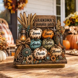 May include: A decorative wooden sign titled Grandma's pumpkin patch featuring six small pumpkins with the names Emma, David, Amelia, Sophia, Charlie, and Thomas. The display includes a lantern, wheat stalks, sunflowers, and a cowboy boot accent.