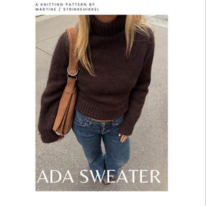 May include: A dark brown long-sleeve turtleneck sweater with ribbed cuffs and hem. The text at the top reads A KNITTING PATTERN BY MARTINE / STRIKKEHIKKEL and the text at the bottom reads ADA SWEATER. The sweater is paired with blue jeans and a tan shoulder bag.