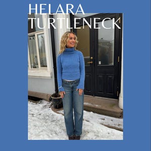 Op de afbeelding: Een persoon draagt een blauwe coltrui en een blauwe spijkerbroek voor een deur. De tekst "HELARA TURTLENECK" wordt in grote witte letters weergegeven. De tekst "A PATTERN BY MARTINE / STRIKKEHIKKEL" staat erboven.
