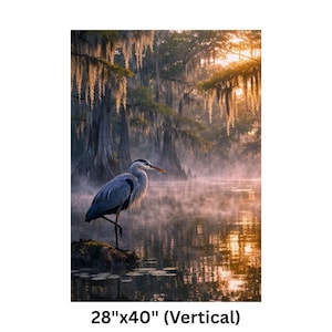May include: A vertical print of a serene wetland scene featuring a great blue heron standing on one leg. The artwork showcases a misty lake, cypress trees, and Spanish moss. The print measures 28" x 40".
