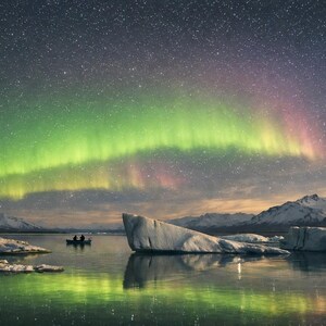 24-048 | Aurora Borealis Art, Reflections, Stargazers on the Ice, Northern Lights Print, Nature photography (Digital Download)

Experience the wonder of the northern lights with Aurora Reflections, a breathtaking fine‑art print capturing two stargazers adrift beneath a glowing Arctic sky. This Aurora Borealis scene blends vivid greens, soft pinks, and pale yellows reflected in still glacial waters — a moment of serenity and awe.