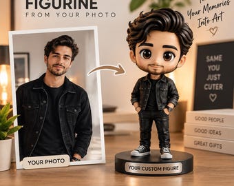 May include: A custom chibi figurine of a person with dark hair and a beard, wearing a black denim jacket, black shirt, black pants, and white sneakers. The figure stands on a black circular base labeled "YOUR CUSTOM FIGURE" next to a photo.