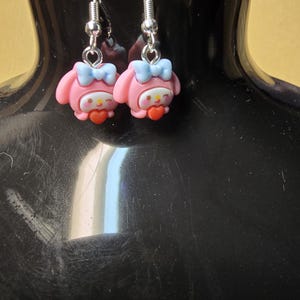 May include: A set of three ceramic mugs with a speckled, matte finish. The mugs are in shades of cream, light gray, and dark gray. Each mug has a simple, minimalist design and a rounded handle.