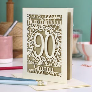 A cream laser cut 90th birthday card with decorative '90' in the centre, 'Happy Birthday' above, and personalised with the name of the recipient underneath.