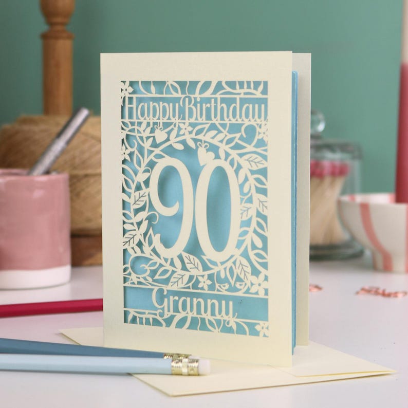A cream laser cut 90th birthday card with decorative '90' in the centre, 'Happy Birthday' above, and personalised with the name of the recipient underneath.