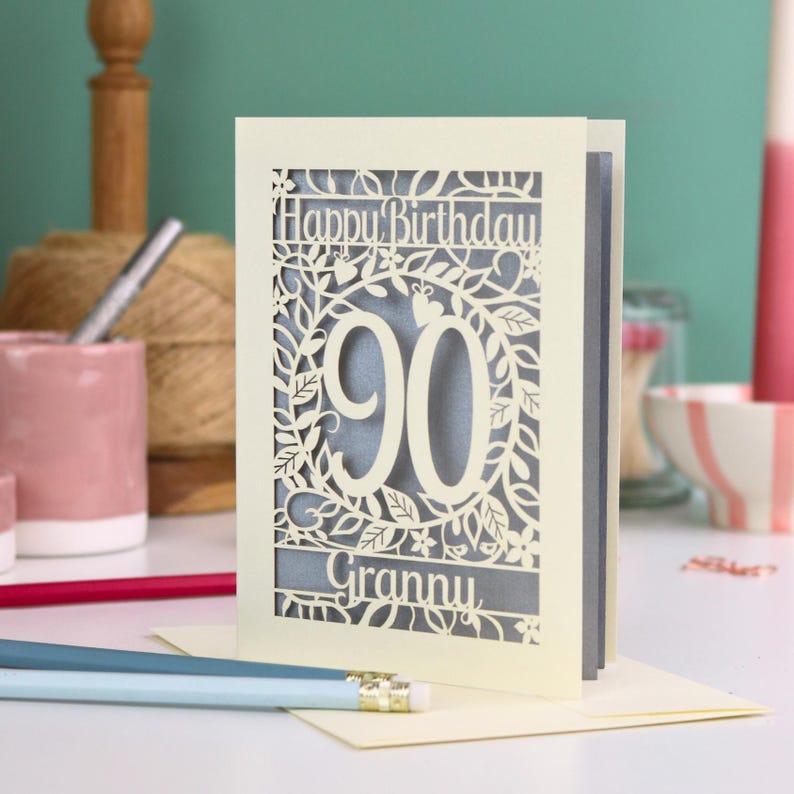 A cream laser cut 90th birthday card with decorative '90' in the centre, 'Happy Birthday' above, and personalised with the name of the recipient underneath.