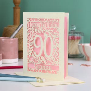 A cream laser cut 90th birthday card with decorative '90' in the centre, 'Happy Birthday' above, and personalised with the name of the recipient underneath.