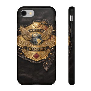 May include: Black phone case featuring a gold and bronze World Champion belt design. The belt has wings, a globe, and the words "WORLD CHAMPION". The case has a leather-like texture.